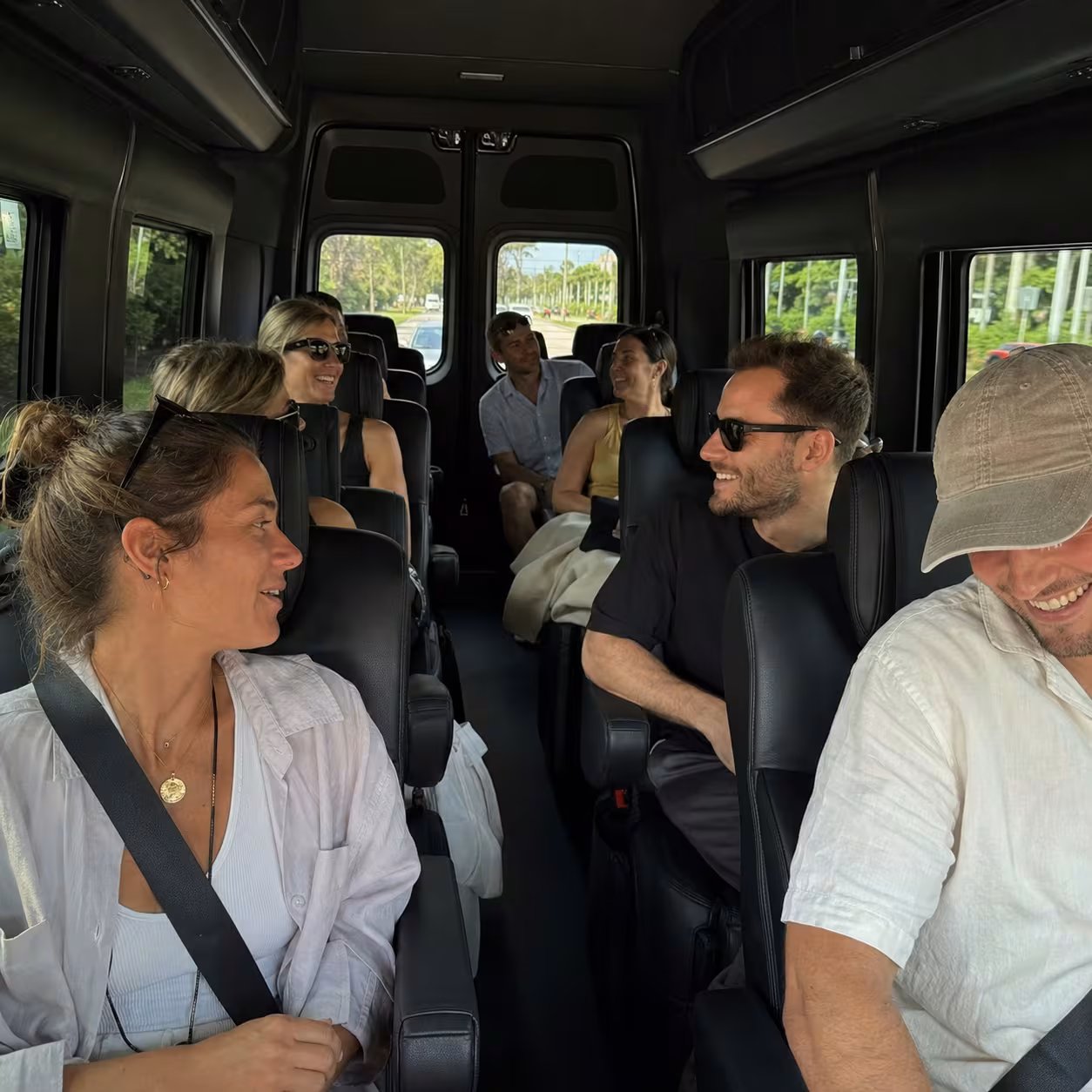 Passengers seated inside a Mercedes Sprinter checking flight times on the way to a Southwest Florida airport