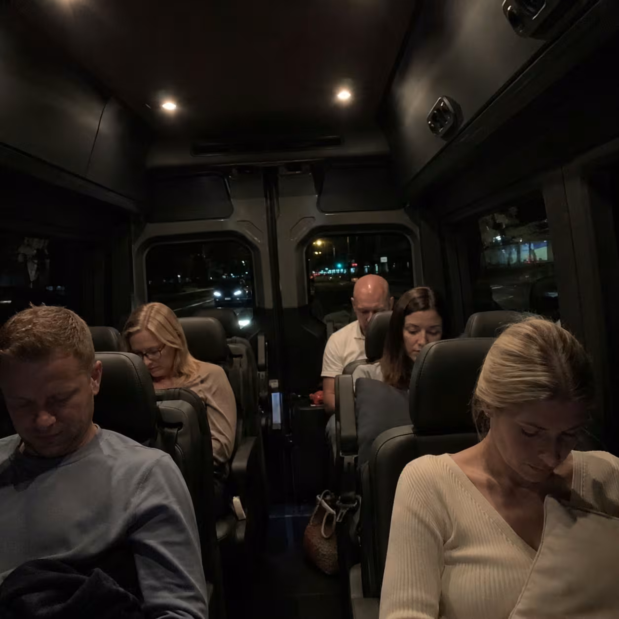 Dimly lit Mercedes Sprinter interior on a late-night red-eye airport transfer in Naples, Florida