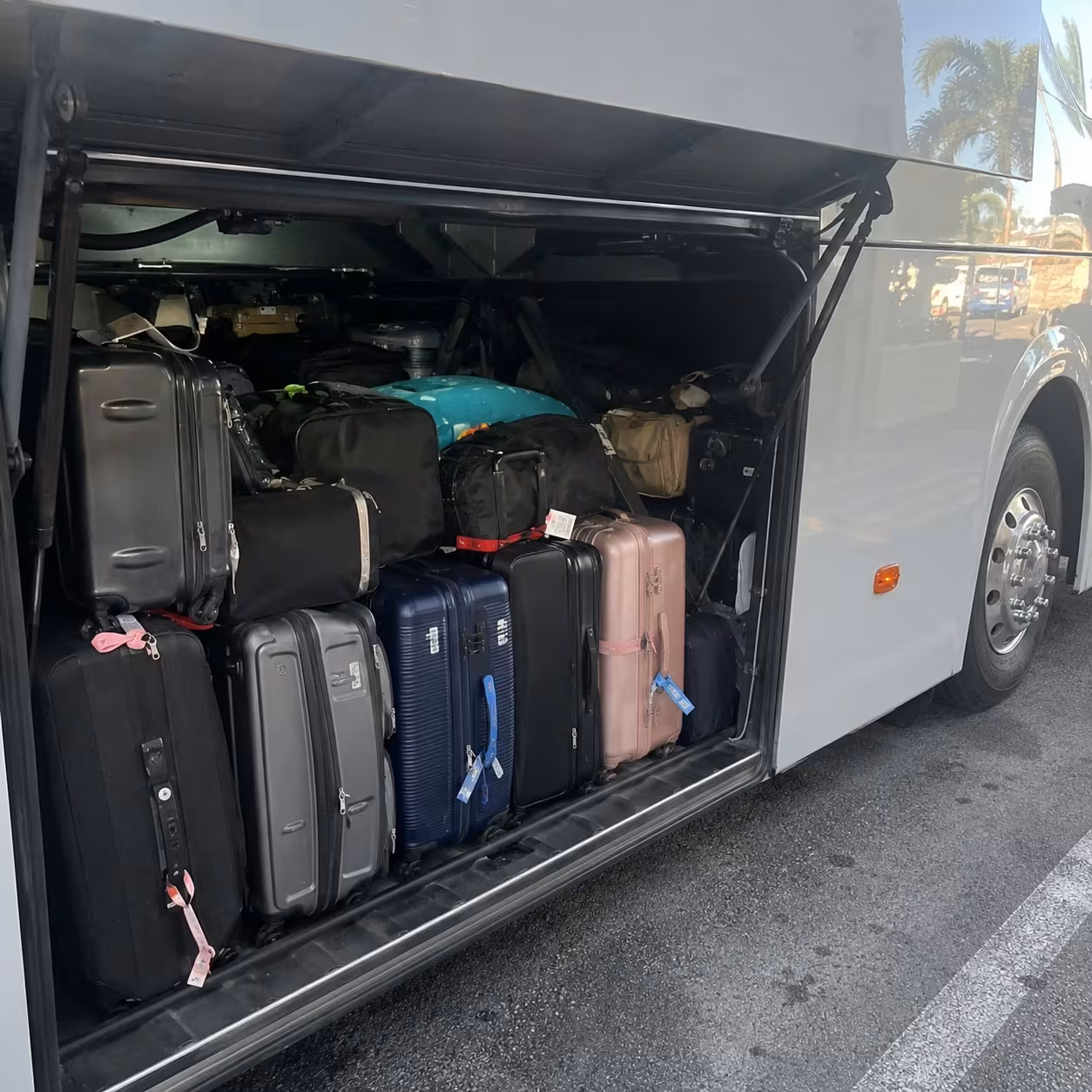 Close-up of a coach luggage bay packed with suitcases for a Naples, Florida airport trip