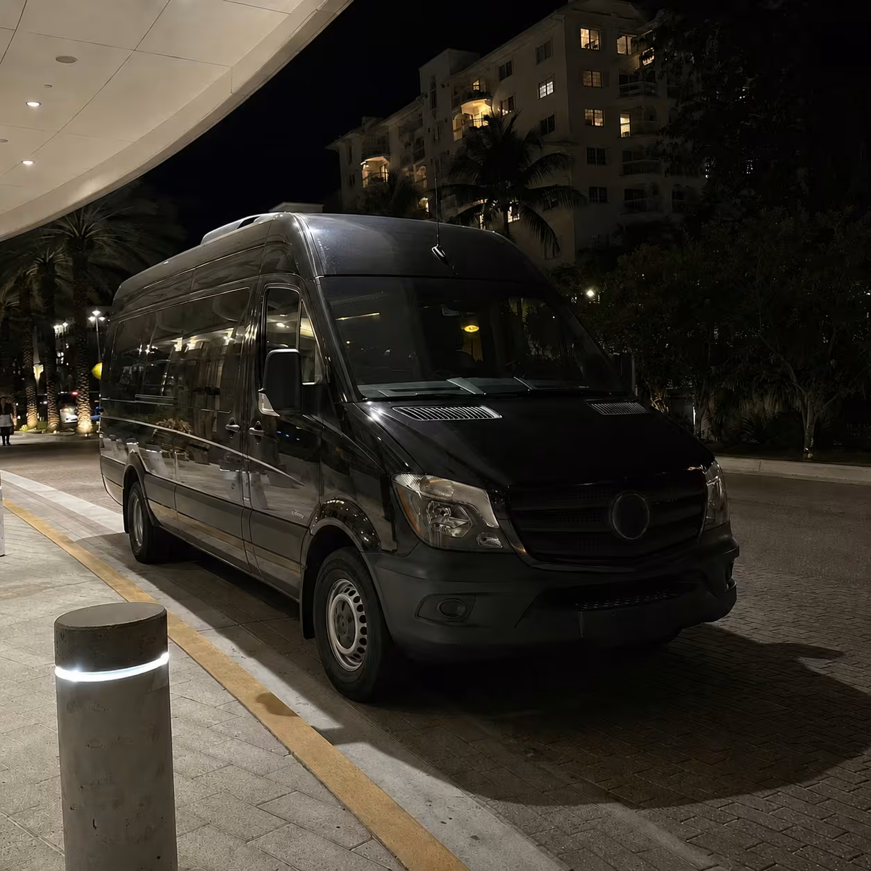Black Mercedes Sprinter waiting curbside for a late-night red-eye airport pickup in Naples, Florida