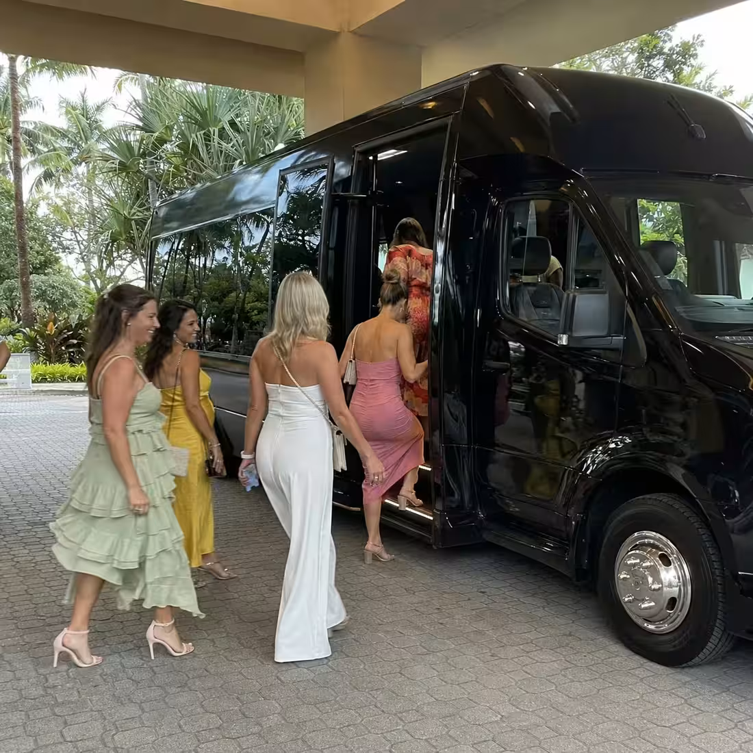 Bachelorette group boarding a black Grech GM24 Sprinter limo at a Naples hotel curb