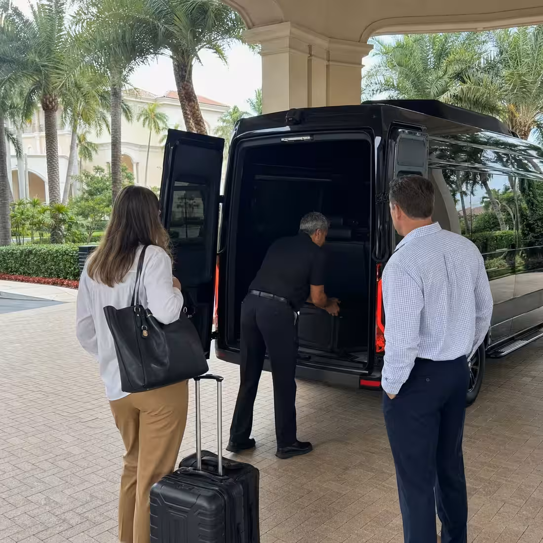 Chauffeur loading luggage into a Sprinter van at a Naples resort for a corporate trip