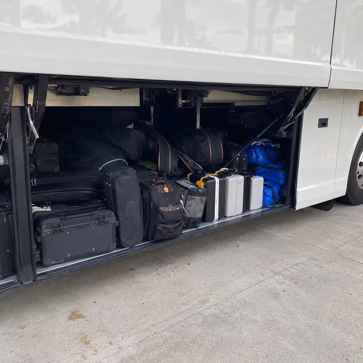 Student gear loaded into a motorcoach luggage bay for a Naples school event