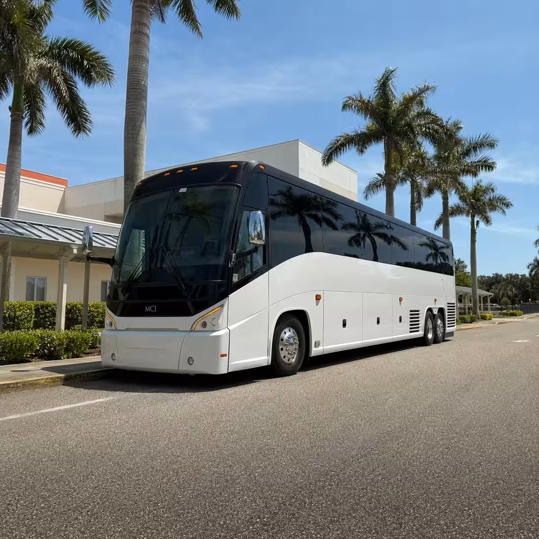 MCI J4500 motorcoach waiting at a Naples school curb for a field trip