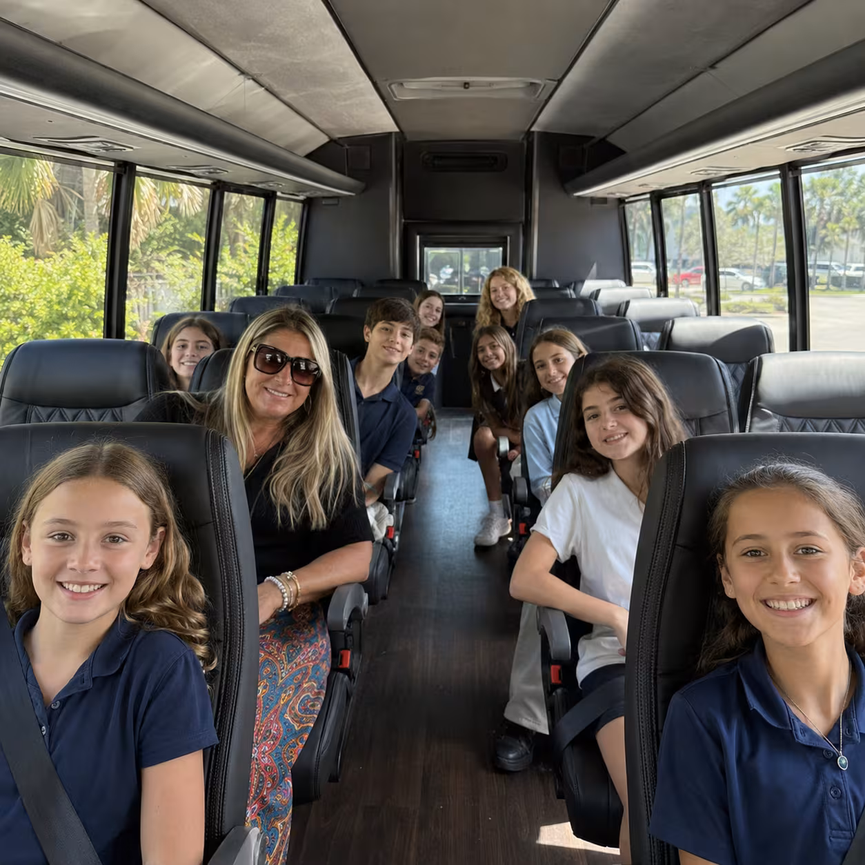Students seated in a cutaway minibus for a Naples school outing