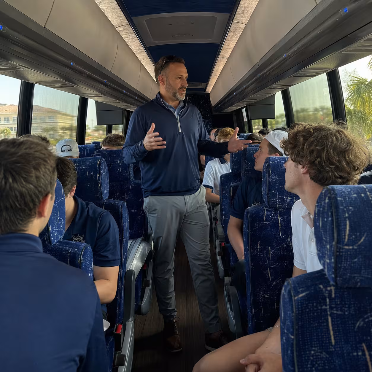 Coach walking the aisle of a motorcoach en route to a game in Naples, Florida