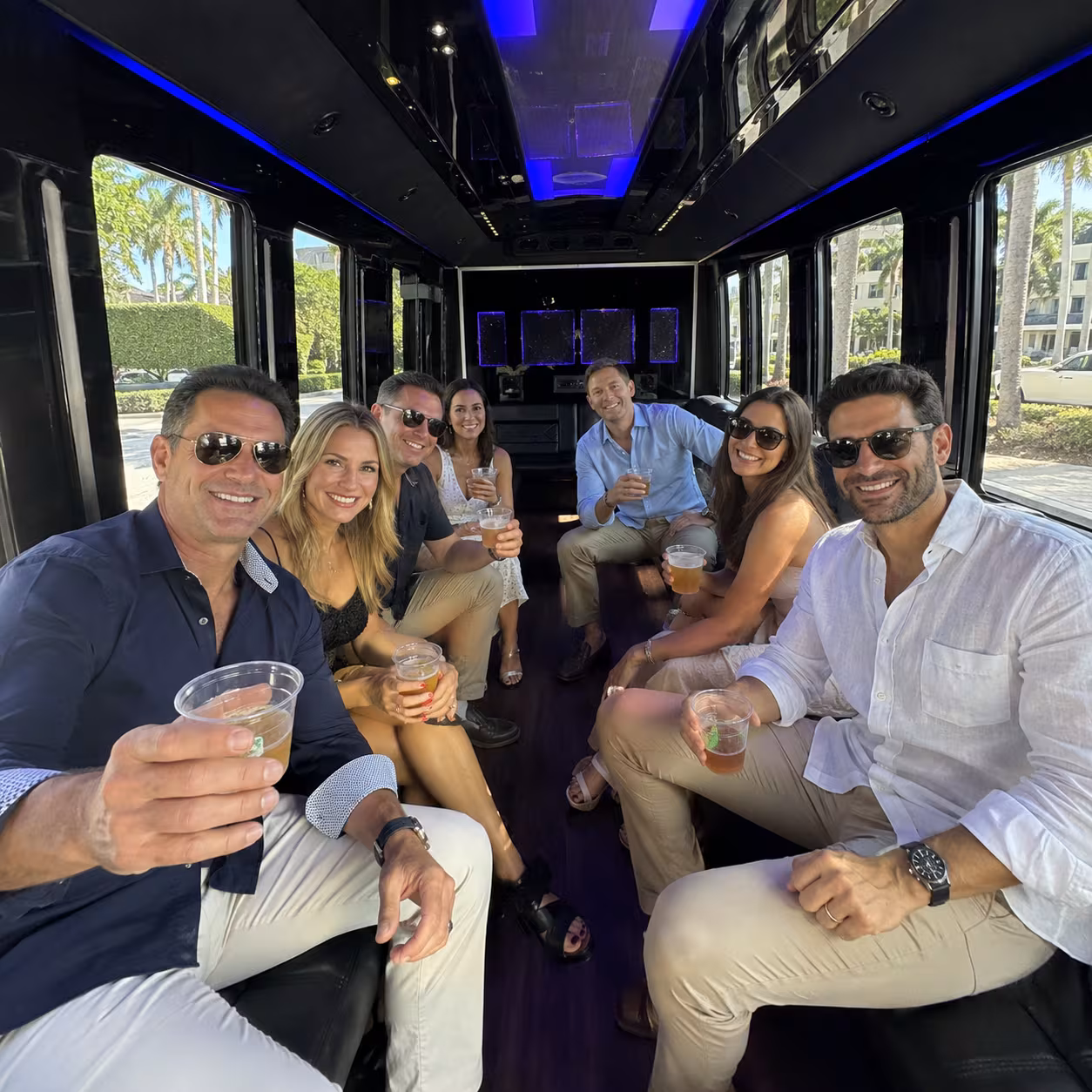 Adults seated in a party bus for a Naples winery tour and pub crawl